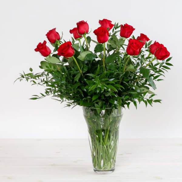 Red roses arranged in a clear glass vase
