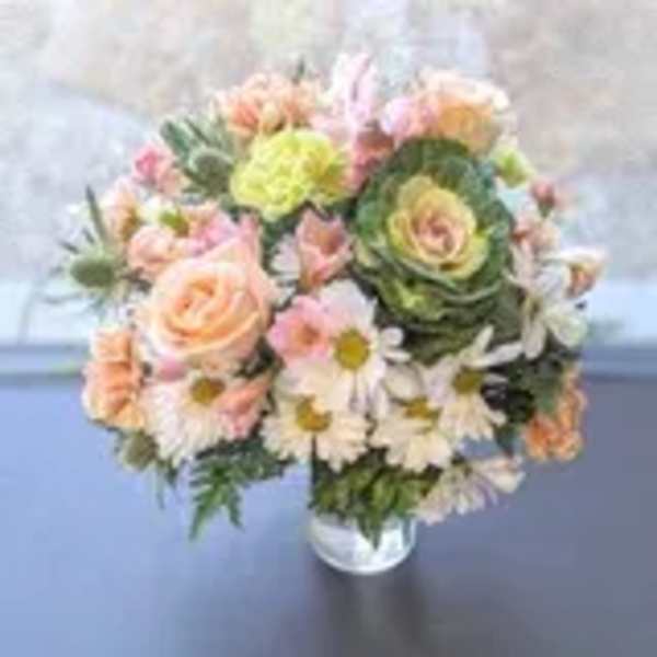 Round bouquet of peach roses, white daisies, and green ornamental blooms in a glass vase