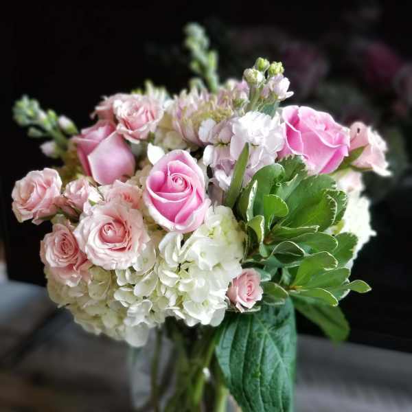 Pink roses and white hydrangeas in a clear glass vase