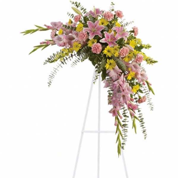 Pink and yellow floral spray on a white easel stand