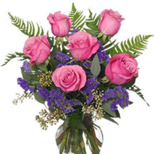 Pink roses arranged in a clear glass vase with purple filler flowers