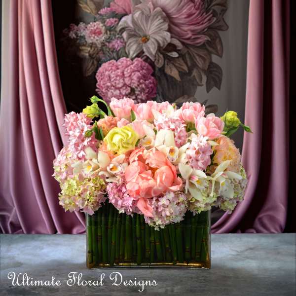 Pink and white flowers arranged in a rectangular glass vase