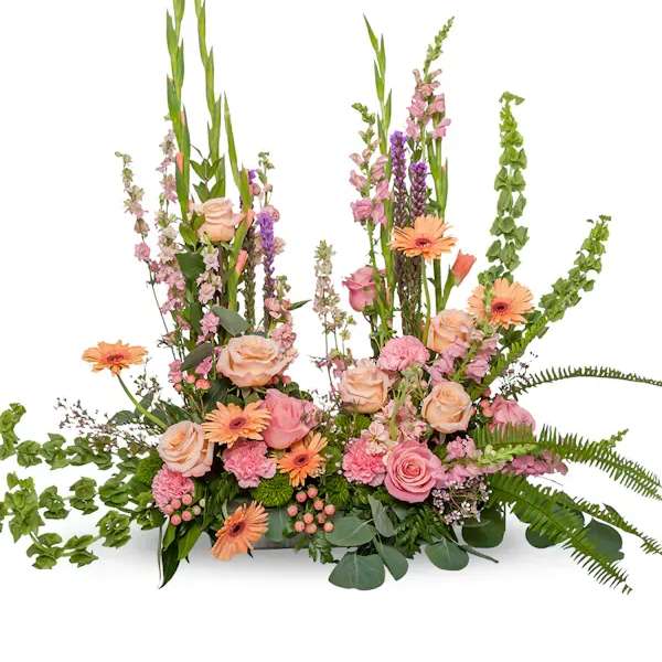 Pink and peach floral arrangement with tall green spikes and orange daisies