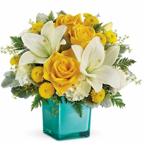 Yellow roses and white lilies in a turquoise vase