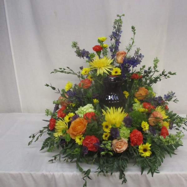Colorful floral arrangement around a dark vase centerpiece