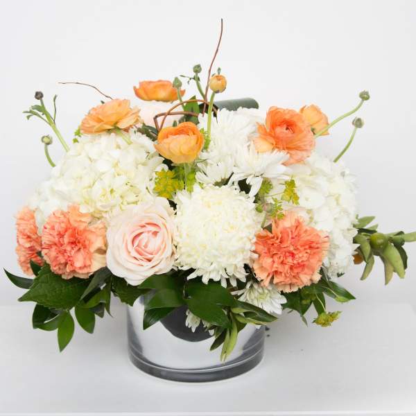 Peach and white floral arrangement in a clear glass vase