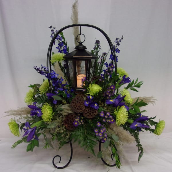 Lantern centerpiece surrounded by purple and green flowers