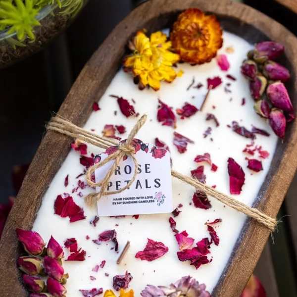 Oval candle topped with dried rose petals and small flowers