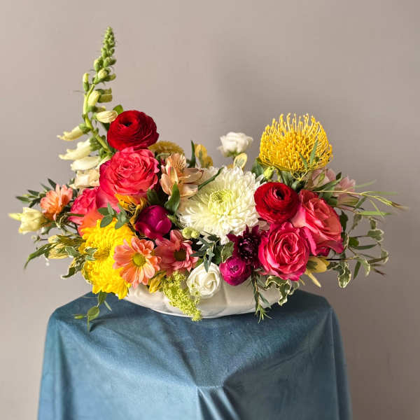 Colorful mixed flower arrangement in a white bowl vase