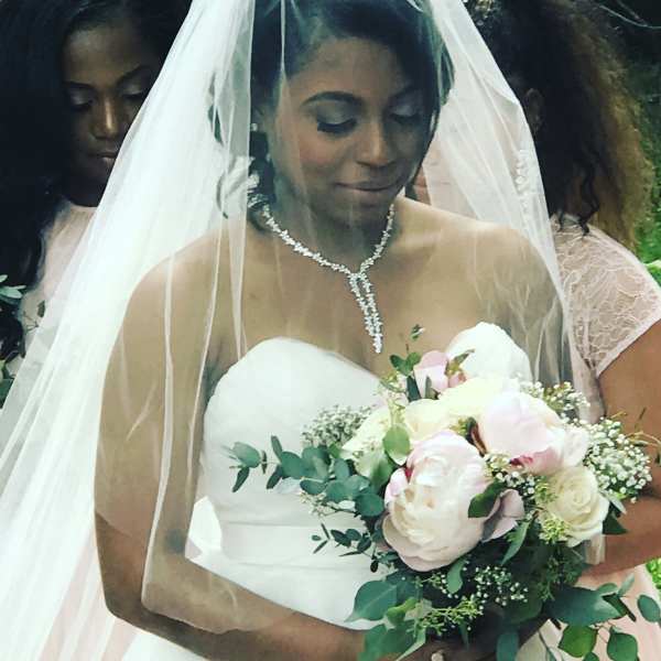 Bride holding a bouquet of pale pink and white flowers
