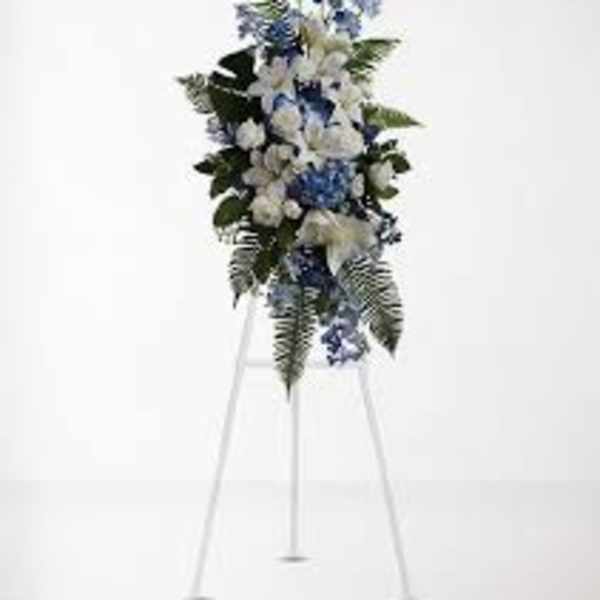 Blue and white funeral spray on a white easel