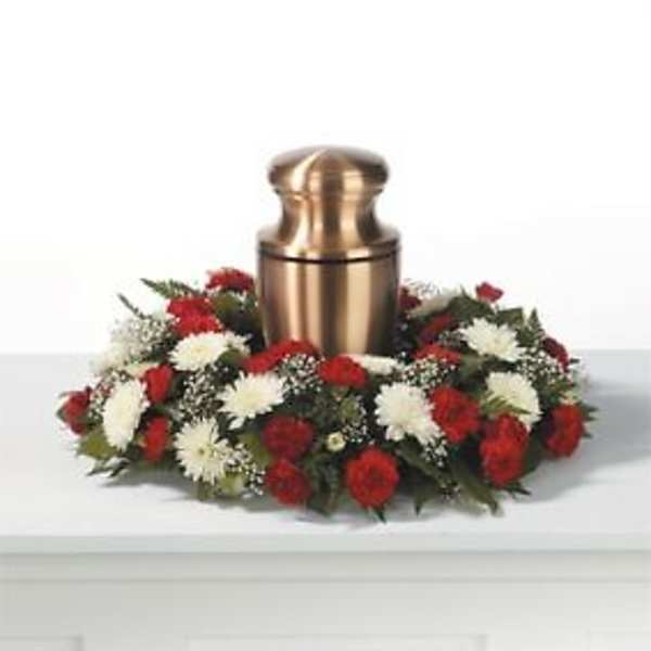 Red and white floral wreath around a bronze urn