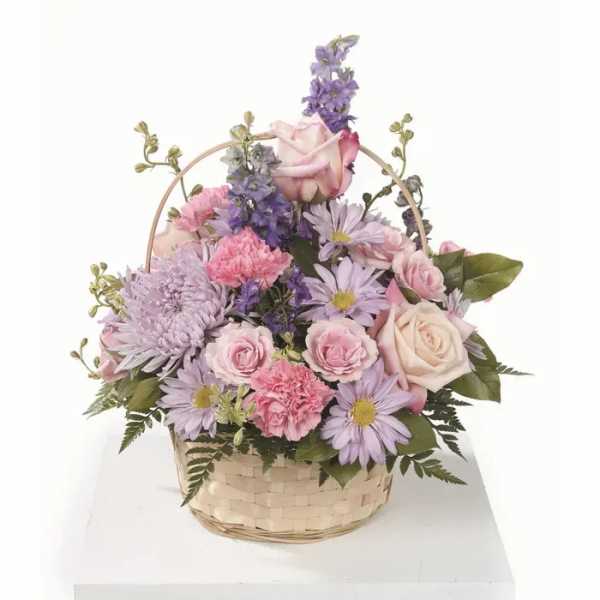 Basket arrangement of pink and lavender flowers with roses and daisies