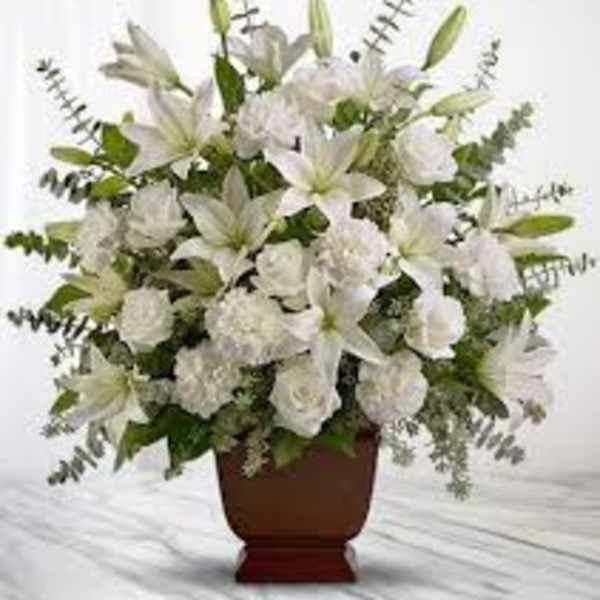 White lilies and roses arranged in a brown vase