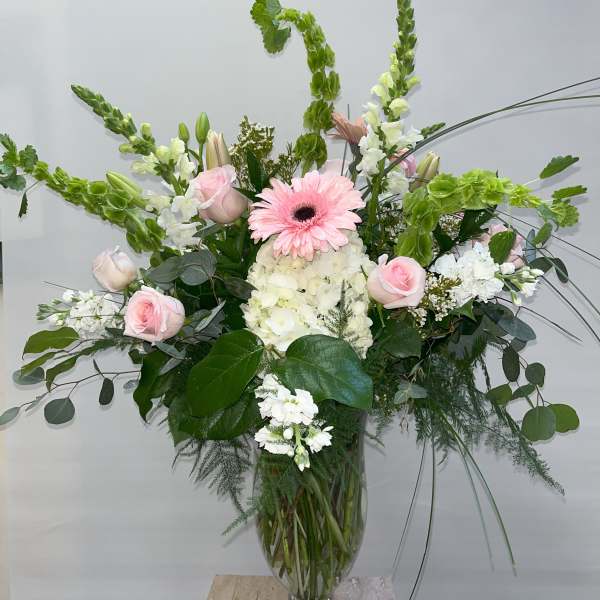 Tall bouquet of pink and white flowers in a clear glass vase