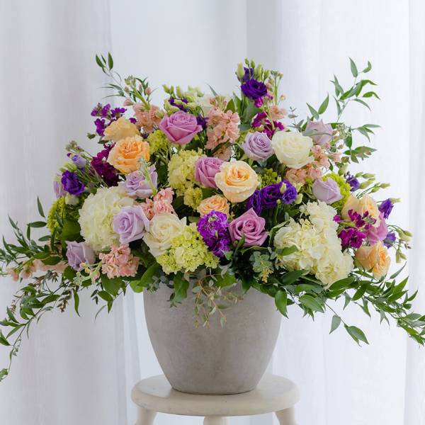 Mixed pastel roses and hydrangeas in a gray vase