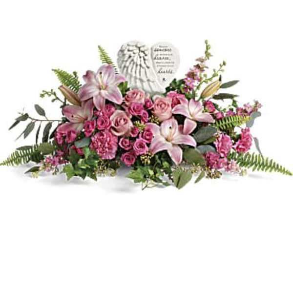 Pink lilies and roses arranged around a memorial heart plaque