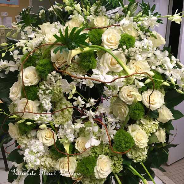 Large white floral arrangement with roses and orchids