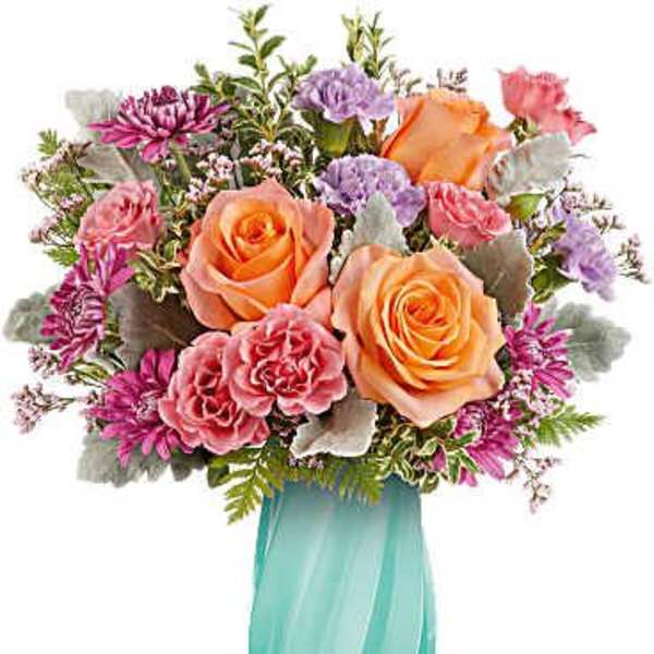 Bouquet of peach and pink roses in a turquoise vase