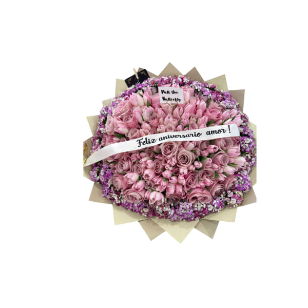 Round bouquet of pink roses with a white anniversary ribbon