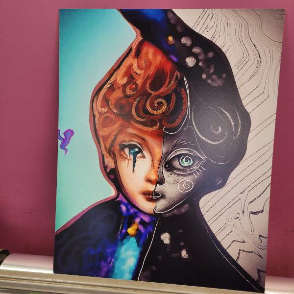 Abstract portrait artwork with a split-color face on a canvas