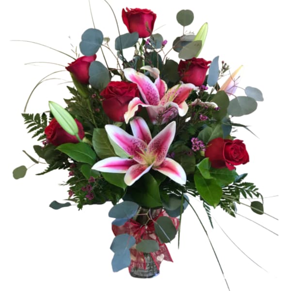 Bouquet of red roses and pink lilies in a glass vase