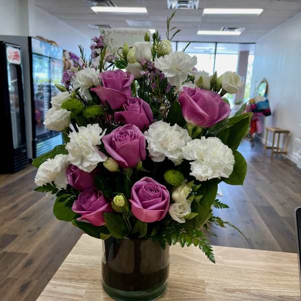 Pink roses and white carnations arranged in a glass vase