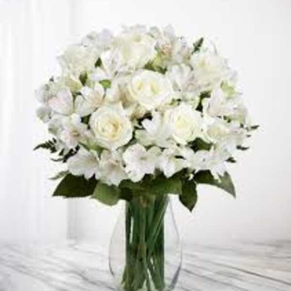 White roses and lilies in a clear glass vase