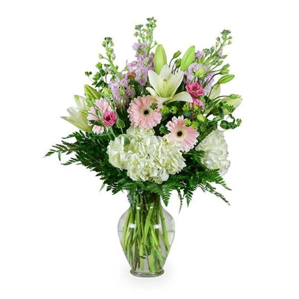 Mixed bouquet of lilies, gerbera daisies, and hydrangeas in a glass vase