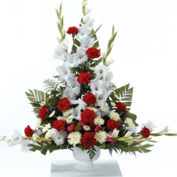 Tall red and white floral arrangement in a clear vase