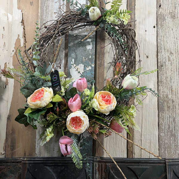 Floral wreath with pink and cream blooms on a twig base