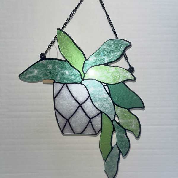 Hanging stained-glass plant with green leaves in a black metal frame
