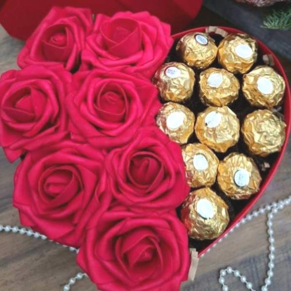 Heart-shaped box with pink roses and gold-wrapped chocolates