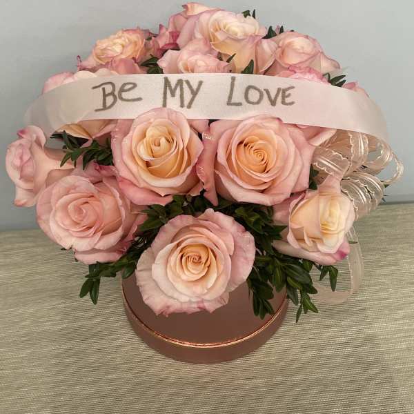 Pink rose bouquet in a round box with a "Be My Love" ribbon