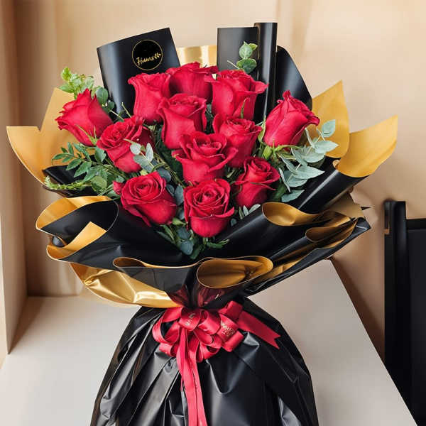 Bouquet of red roses wrapped in black and gold paper with a red ribbon