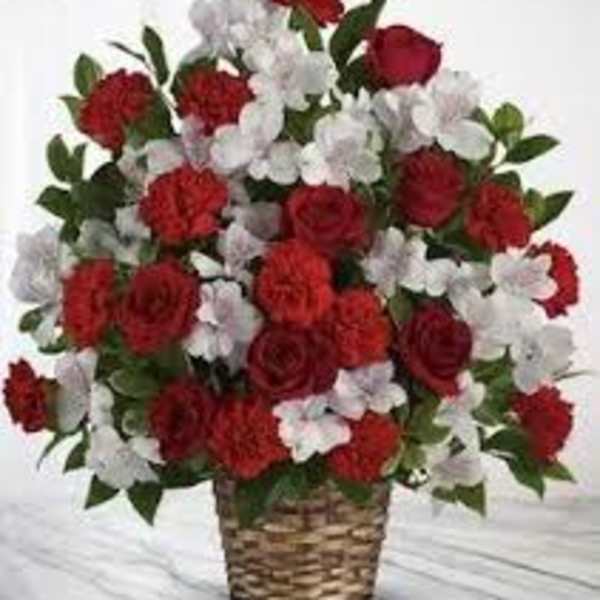 Red roses and white carnations in a woven basket