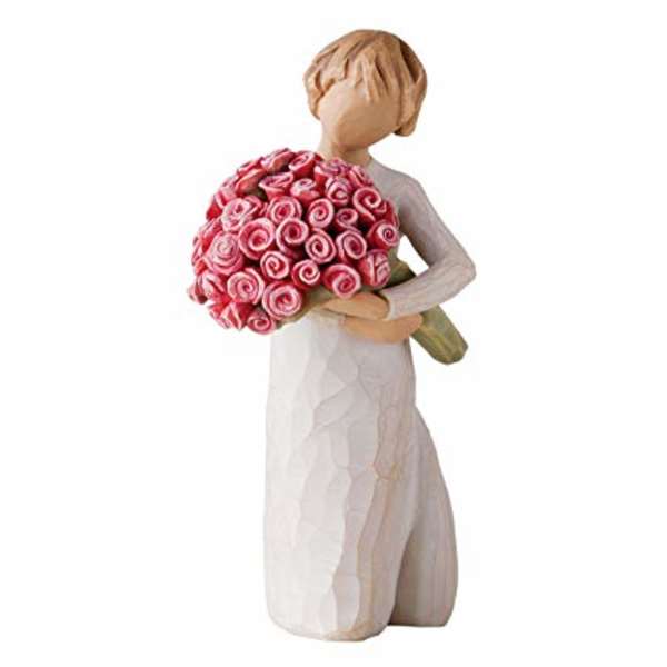 Figurine of a woman holding a bouquet of pink roses