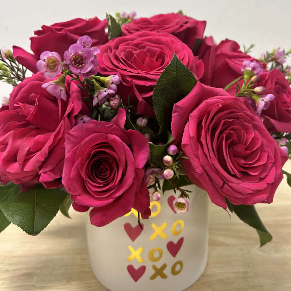 Hot pink roses with small pink blossoms in a white mug