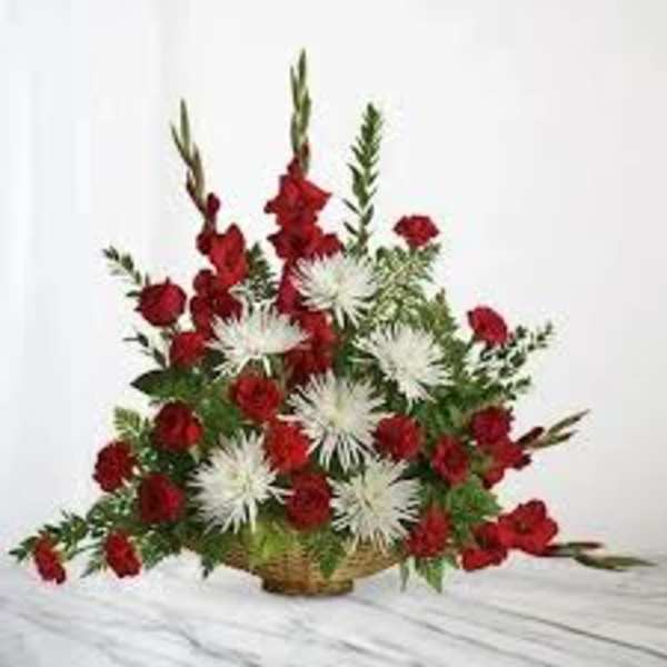 Red and white floral arrangement in a woven basket