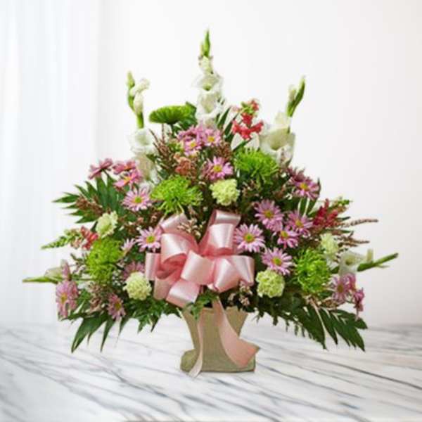 Pink and white mixed flower arrangement in a vase with a pink ribbon