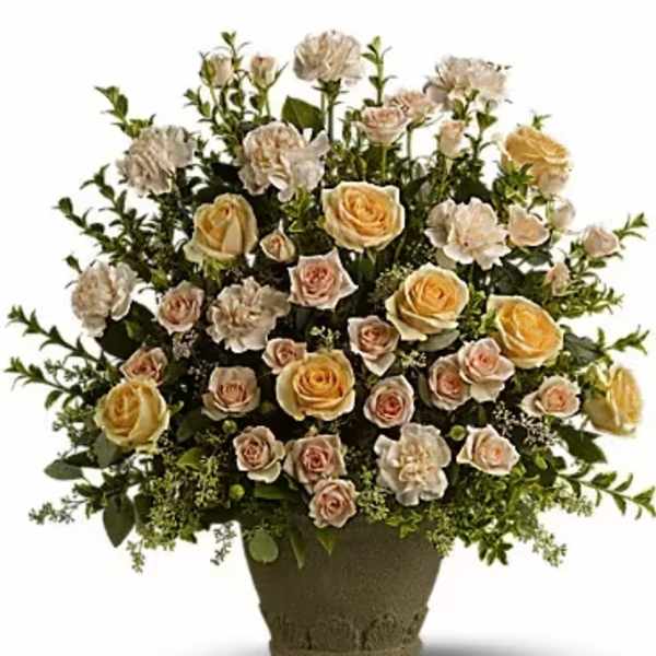 Arrangement of pale roses and carnations in a textured vase