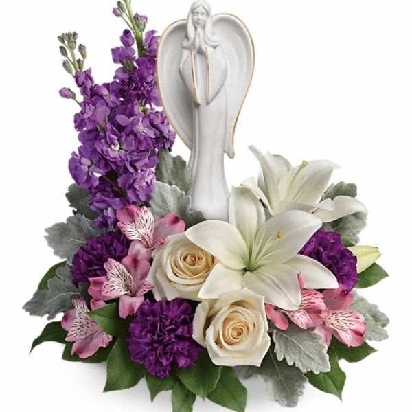 Purple and white floral arrangement with an angel figurine