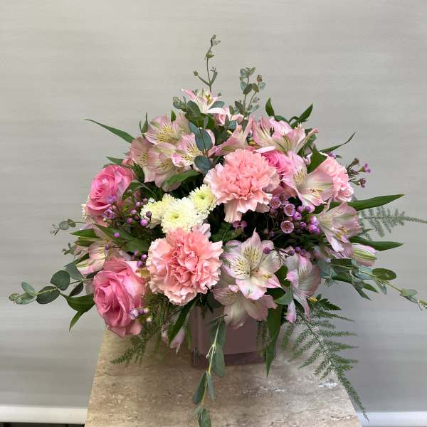 Pink roses and carnations with pale alstroemeria in a vase