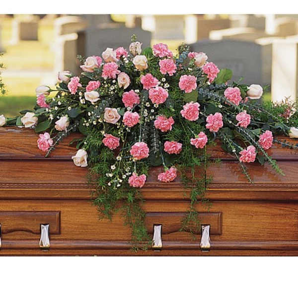 Pink carnations and pale roses arranged on a casket