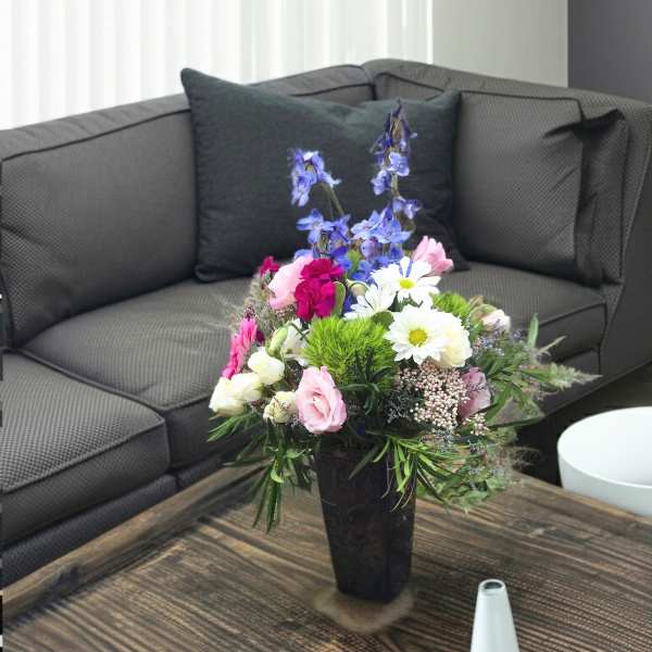 Mixed bouquet in a black vase with pink, white, and blue flowers