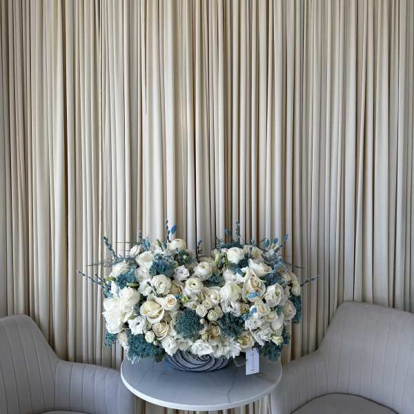 Large white and blue floral arrangement on a round table