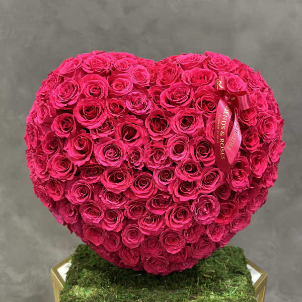 Heart-shaped bouquet of hot pink roses on a moss-covered base