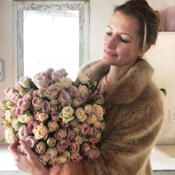 Woman holding a large bouquet of pastel roses