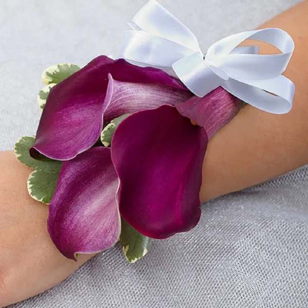 Purple calla lily wrist corsage with a white ribbon