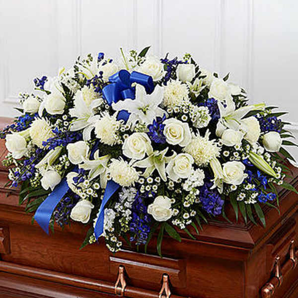 White and blue floral casket spray with a blue ribbon